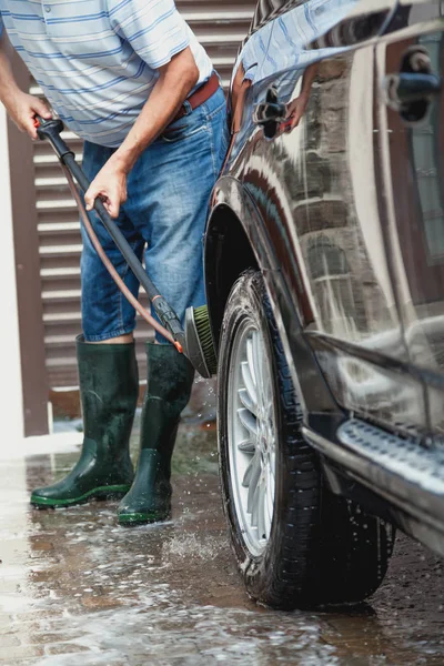 Hombre lava coche moderno en el patio — Foto de Stock