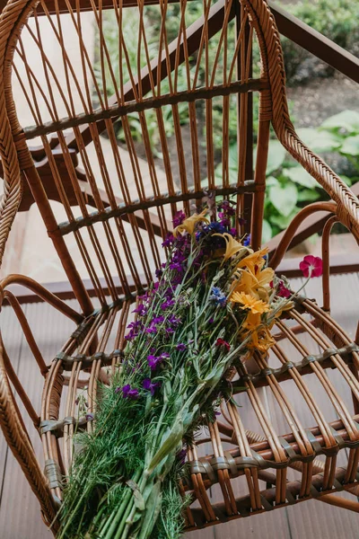 Buquê de flores deitadas na cadeira de vime — Fotografia de Stock