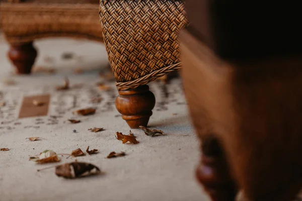 Leg of wicker furniture is on carpet