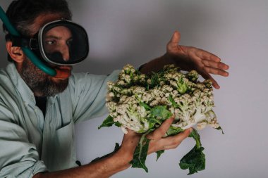 Yüzme maskeli adam karnabahar tutuyor