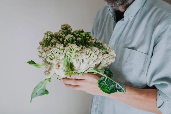 Man in swimming mask is holding  cauliflower