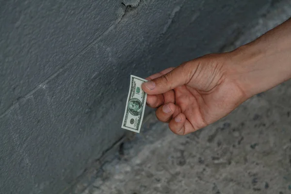 Χέρι παίρνει το λογαριασμό παιχνίδι από τσιμεντένιο πάτωμα — Φωτογραφία Αρχείου
