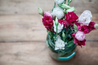 Buket kırmızı çiçek ahşap kurullarında vazoda Eustoma