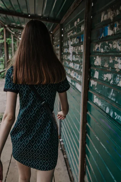 Chica alta camina a lo largo de valla de metal — Foto de Stock