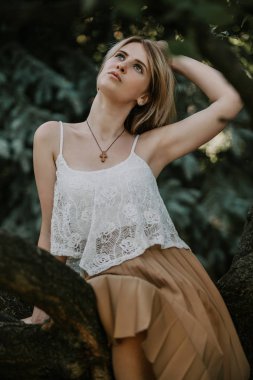 Sevimli sarışın ağaç üzerinde oturur