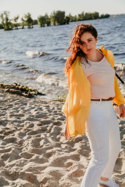 Kumlu sahilde sarı ceket güzel artı boyutu kadın