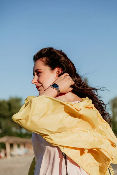 Hermosa mujer de talla grande en chaqueta amarilla contra el cielo azul — Foto de Stock