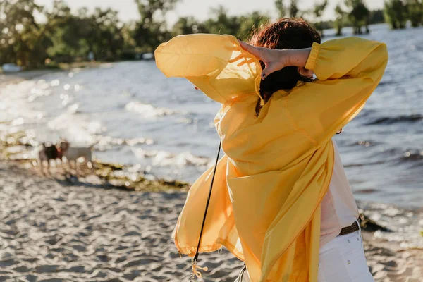 Hermosa mujer de talla grande en chaqueta amarilla en la orilla arenosa — Foto de Stock