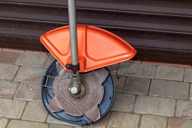 Manuel biçme makinesi kaldırım levhaları üzerinde duruyor