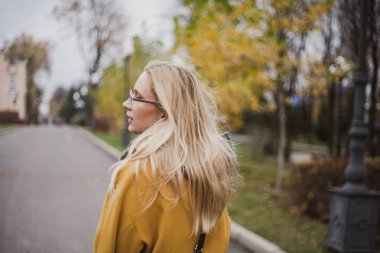 Sonbahar parkında sevimli sarışın Portresi