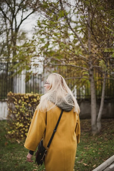 Rubia delgada está caminando en el parque de otoño — Foto de Stock