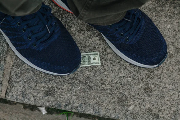 Large sneaker and  small bill lie on granite step — Stock Photo, Image