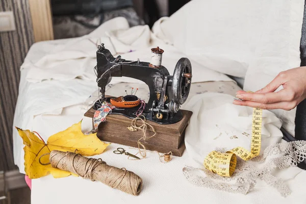 Costureras de mesa de trabajo. Máquina de coser a mano se encuentra en lin blanco —  Fotos de Stock