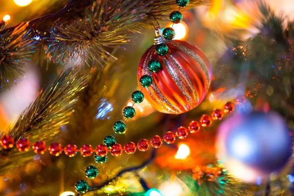 Beautiful garlands hanging on Christmas tree close-up Stock Photo