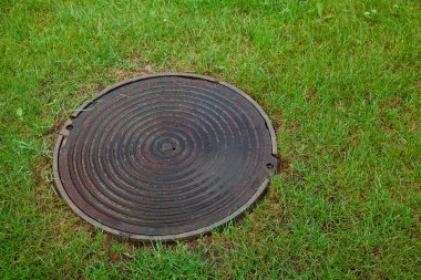 Çimenler üzerinde kapalı kanalizasyon kuyusu