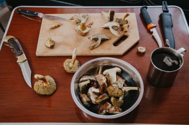 Sofra mantarı toplayıcısı. Dilimlenmiş mantar ve bıçak üzerinde  