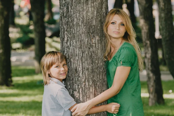 Rodinný portrét. Máma a syn vedle velkého stromu — Stock fotografie
