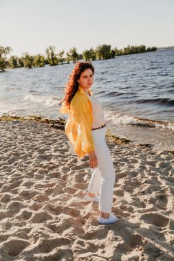 Kumlu sahilde sarı ceket güzel artı boyutu kadın