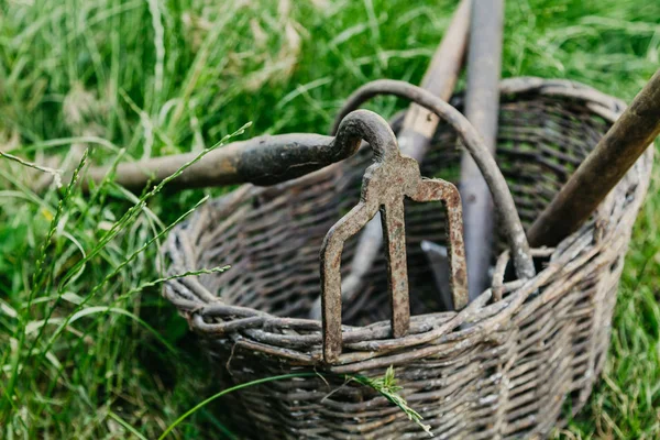 Old hoe of  original form lies on  wicker basket — Stock Photo, Image