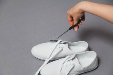 Yeni beyaz spor ayakkabıları kapalı makas el keser etiket