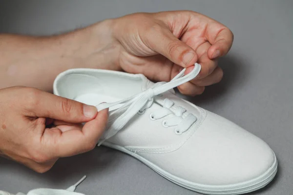 Hands tie  lace on new white sneaker