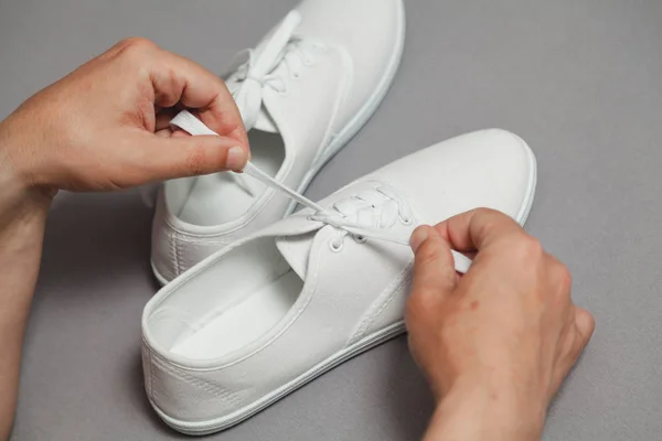 Hands tie  lace on new white sneaker