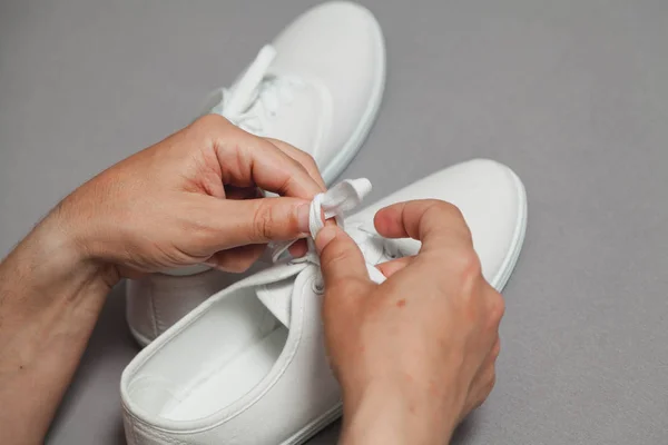 Hands tie  lace on new white sneaker