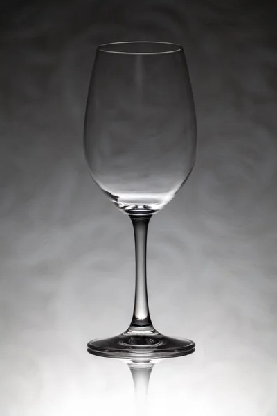 Glass wine glass stands on a blurred background — Stock Photo, Image