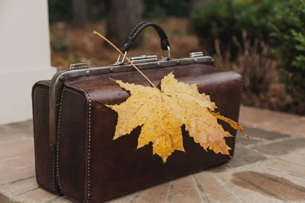 Leather bag is on brick fence