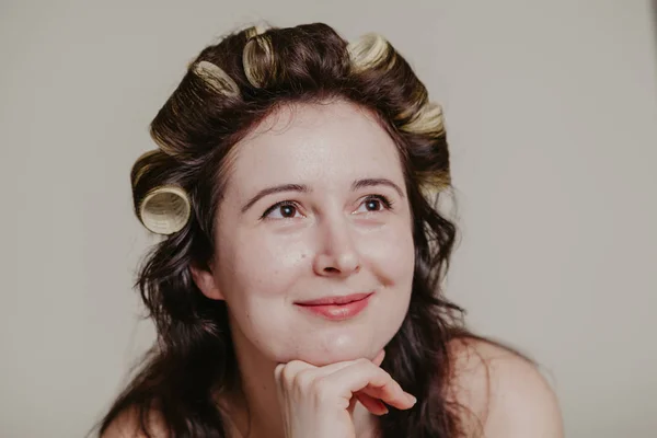 Девушка с родимым пятном на щеке с бигудями в волосах — стоковое фото