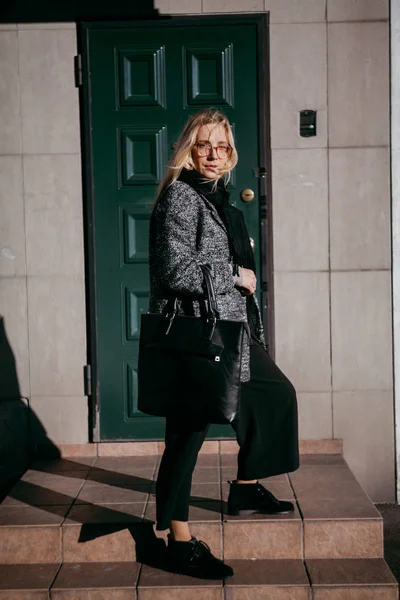 Élégante blonde se tient sur les marches devant la porte verte — Photo