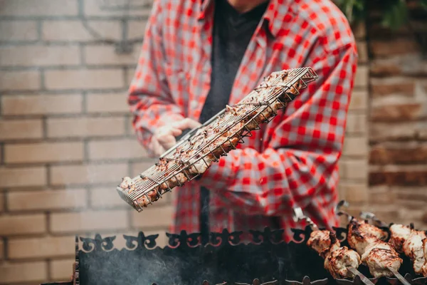 Hand flips barbecue grill op grill — Stockfoto