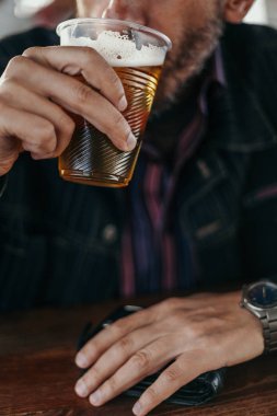 Plastik bardaktan bira içen adam