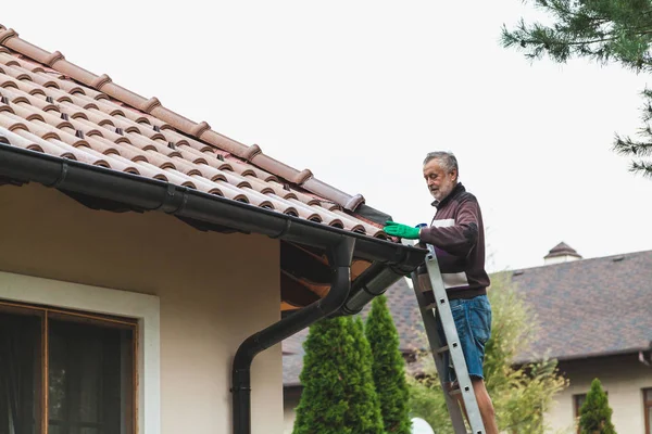 Homem reparos telha telhado da casa moderna — Fotografia de Stock