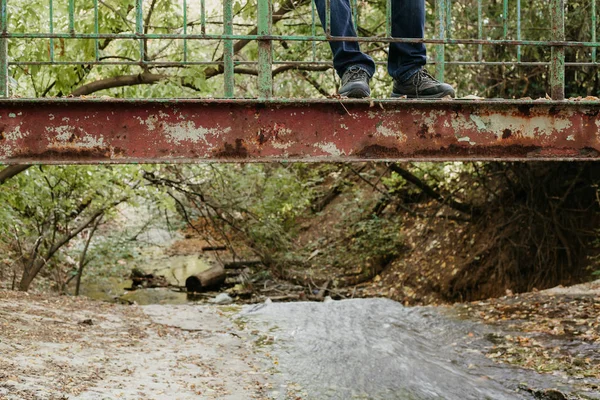 Πόδια του ανθρώπου σε παλιά μεταλλική γέφυρα. Πλευρική όψη — Φωτογραφία Αρχείου