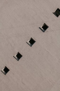 Gri duvarda kare pencere sırası