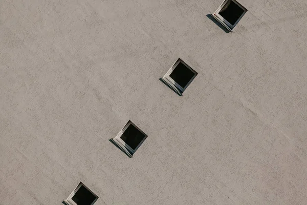Fila de ventanas cuadradas en la pared gris — Foto de Stock