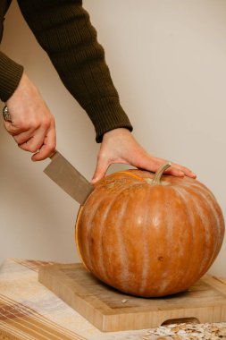 Adam elleri büyük bıçak ile olgun kabak kesti