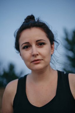 Mavi gökyüzüne karşı siyah t-shirt güzel kahverengi saçlı kadın