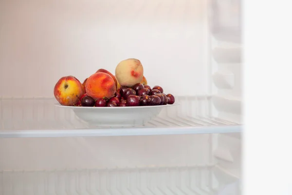 Набор фруктов в пустом открытом холодильнике — стоковое фото