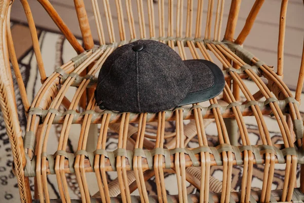 Casquette avec visière repose sur chaise en osier — Photo