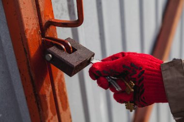 Hand opens padlock with key