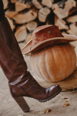 Deri şapkalı kadın çizmesi ve balkabağı