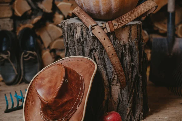 Deri şapka kütüğün üzerinde duruyor. Kemer en üstte.