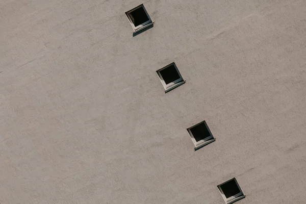 Row of square windows on gray wall