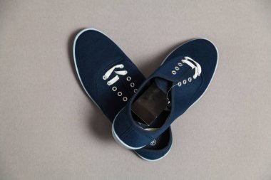 Beyaz tabanlı ve bağcıklı iki yeni mavi spor ayakkabı beyaz, izole bir arka planda duruyor.