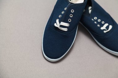 Beyaz tabanlı ve bağcıklı iki yeni mavi spor ayakkabı beyaz, izole bir arka planda duruyor.