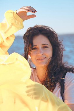 Uzun kızıl saçlı hoş bir kız su yüzeyinin arka planında duruyor. Doğal kusurlarıyla rötuş yapmayan bir kadının portresi