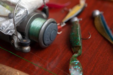 Bir dizi dönüş. Balık oltası ve birkaç vibro-kuyruklu makaralar kahverengi bir surfac üzerinde uzanıyor.