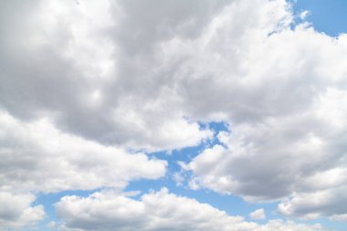 Güzel, yoğun beyaz kümülüs bulutları. Mavi gökyüzü bulutlar arasındaki boşlukta görünür.